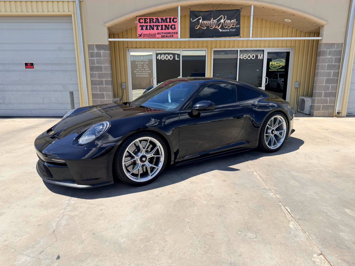 Black Porsche 911 GT3 Touring with fresh tint outside the Luxury Kings shop